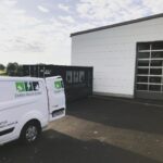 Außenansicht eines Betriebsgebäudes mit Firmenfahrzeug und Container der Elektro Reichl GmbH.