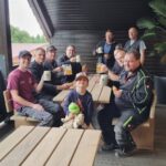 Mitarbeitende sitzen gemeinsam an einem Tisch und genießen eine Brotzeit auf der Terrasse.