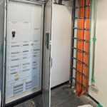 Geöffneter Schaltschrank mit Elektroverteilung und geordneten Kabelsträngen.