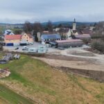 Drohnenaufnahme des Betriebsgeländes mit Werkstätten, Lagerflächen und umliegender Landschaft.