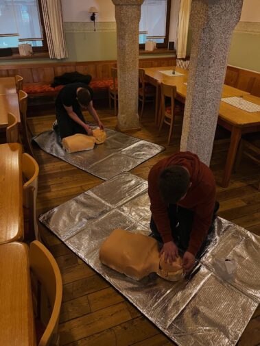 Zwei Mitarbeiter üben die Herzdruckmassage an Reanimationspuppen während einer Erste-Hilfe-Schulung.