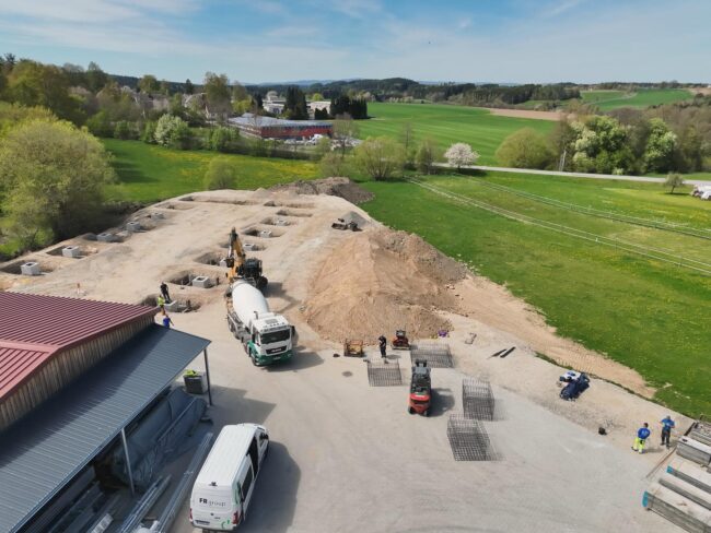 Erdarbeiten und Fundamentvorbereitung Drohnenaufnahme einer Baustelle mit Aushubarbeiten, Fundamentgruben und Baufahrzeugen zur Vorbereitung eines Neubaus.