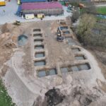 Baustelle mit mehreren ausgehobenen Fundamentfeldern für ein neues Gebäude. Die Aufnahme zeigt den Fortschritt der Gründungsarbeiten.