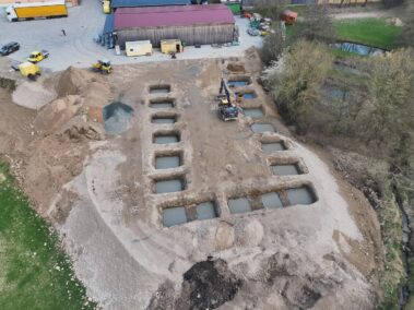 Baustelle mit mehreren ausgehobenen Fundamentfeldern für ein neues Gebäude. Die Aufnahme zeigt den Fortschritt der Gründungsarbeiten.