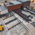 Drohnenaufnahme einer Industrieanlage mit Fördertechnik, Stahlkonstruktionen und Maschinen für automatisierte Produktionsprozesse.