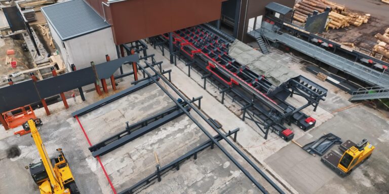 Drohnenaufnahme einer Industrieanlage mit Fördertechnik, Stahlkonstruktionen und Maschinen für automatisierte Produktionsprozesse.