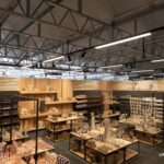 Innenansicht eines Verkaufsraums mit moderner LED-Beleuchtung, dekorativen Warenpräsentationen und offenem Hallenkonzept.