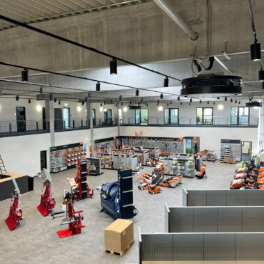 Großzügiger Verkaufsraum eines Technik- und Maschinenfachmarktes mit ausgestellten Geräten, Regalsystemen und offener Galerieebene unter einer modernen Industriehallendecke.