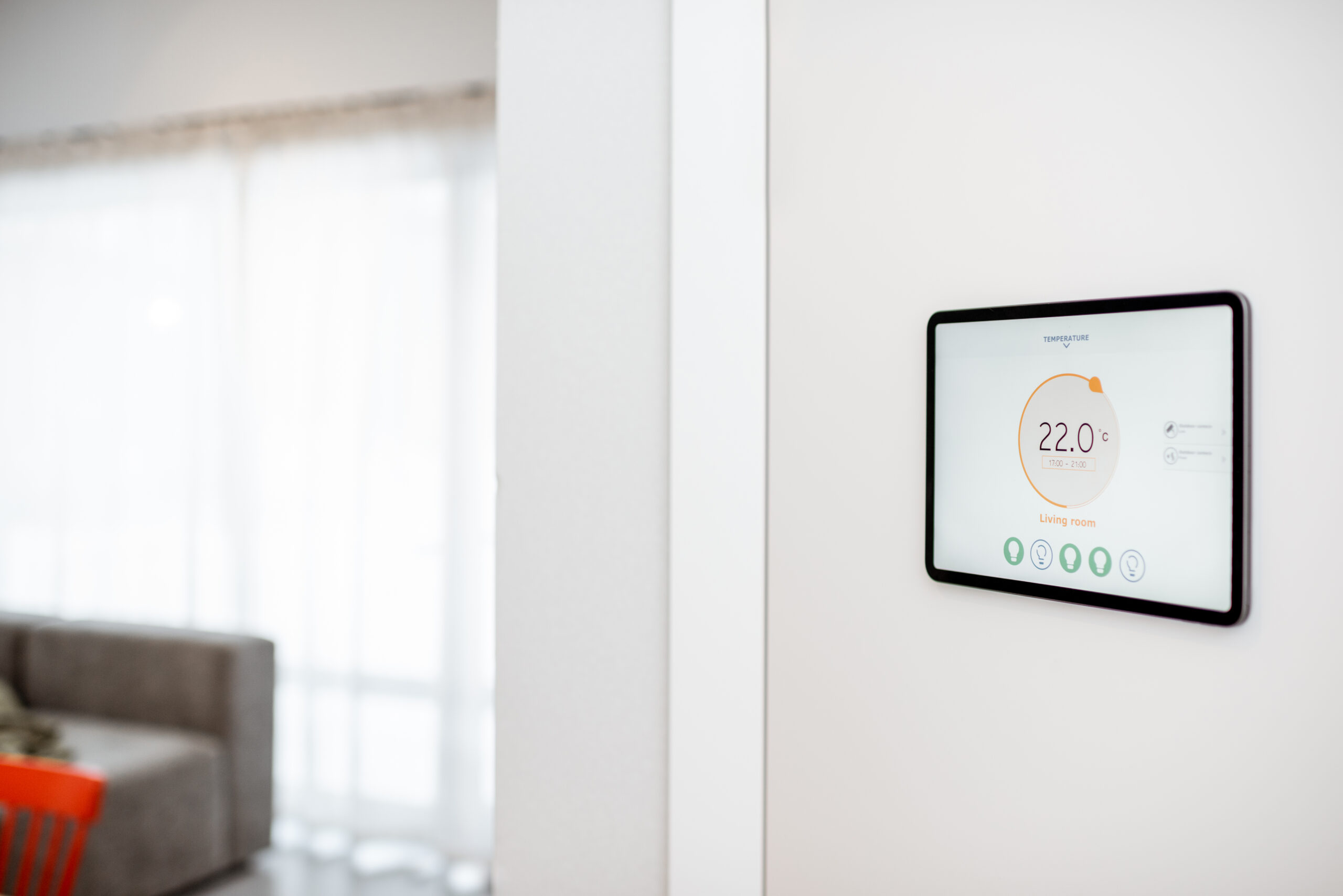 Wandmontiertes Smart-Home-Bedienpanel zur Steuerung von Raumtemperatur und Gebäudefunktionen.